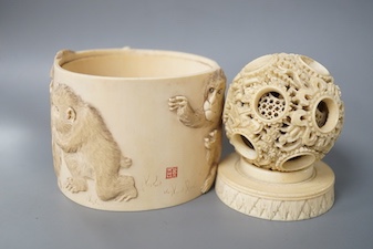 A late 19th century Chinese carved ivory concentric ball comprising seven reticulated spheres, with a small stand, and a Japanese carved ivory box (base missing), Meiji period, of cylindrical form, decorated with a black